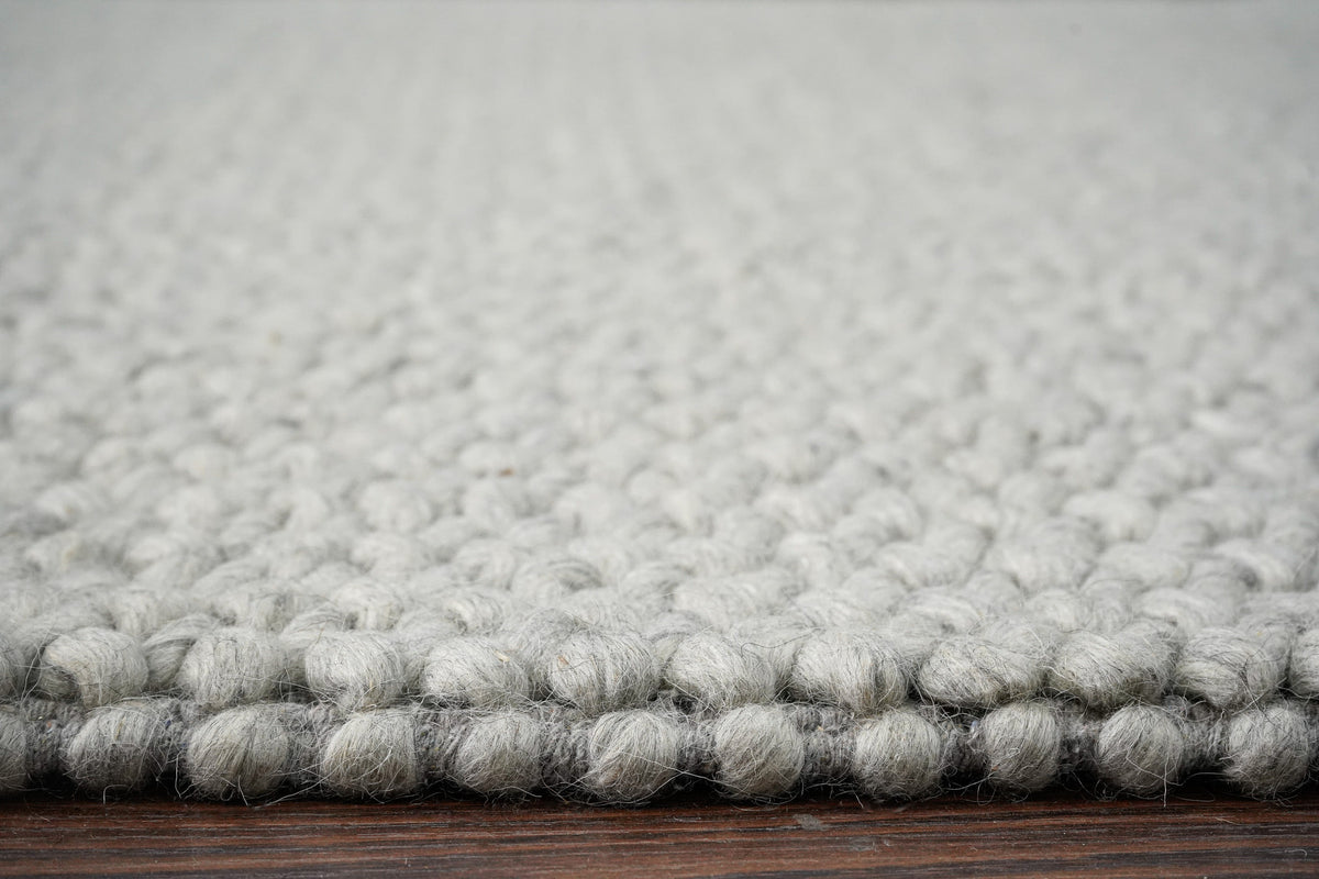 Gray Cashew Loops — wool rug viewed at floor level to show the raised loop surface along the edge