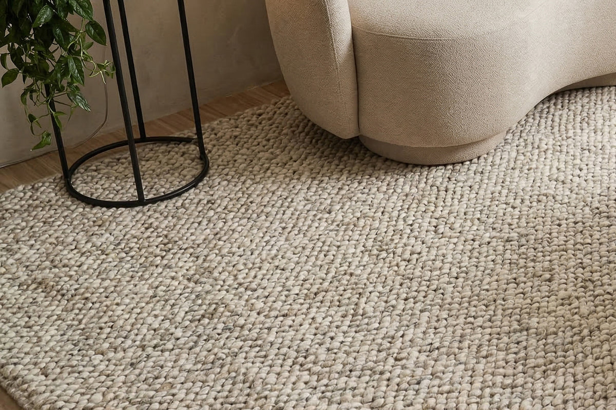Gray Cashew Loops — texture of the wool rug up close in a styled room beside a curved chair and black plant stand