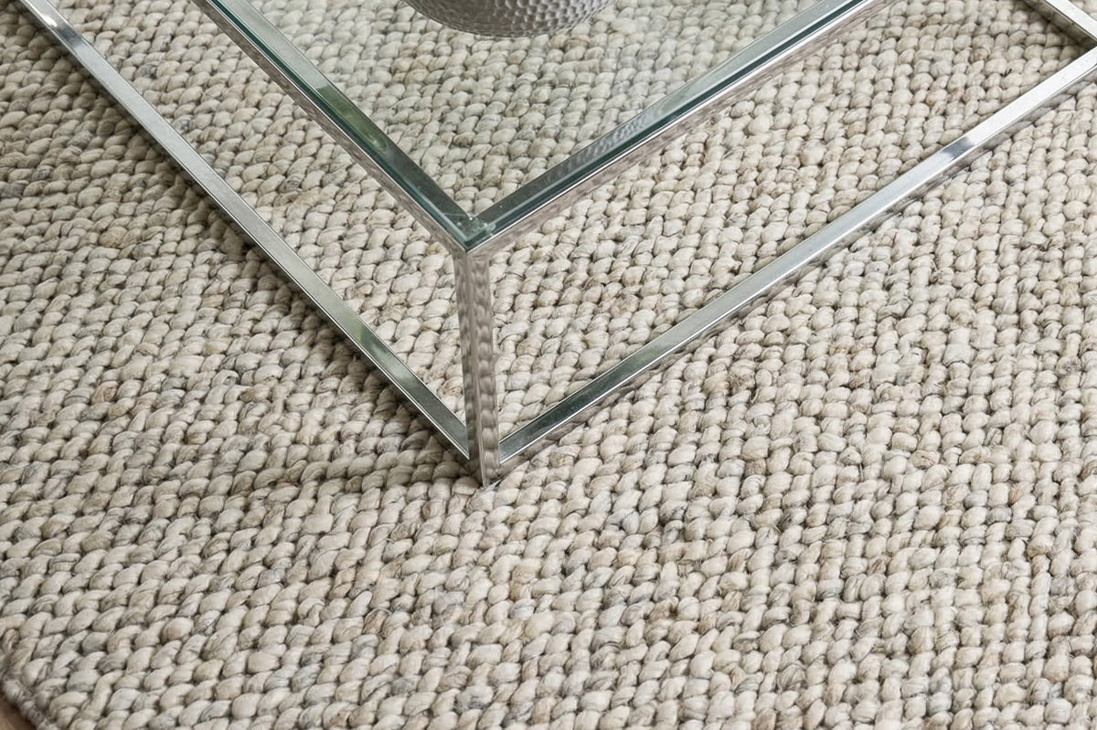 Cashew Loops — wool rug with ivory and gray loops beneath the corner of a glass and metal table