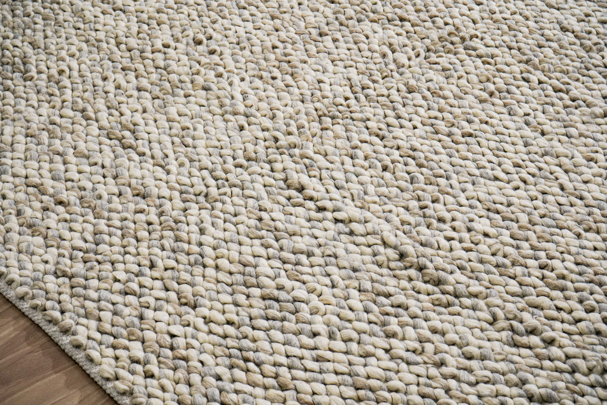 Gray Cashew Loops — close-up of the weave, chunky loop pile and edge finish beside a wood floor