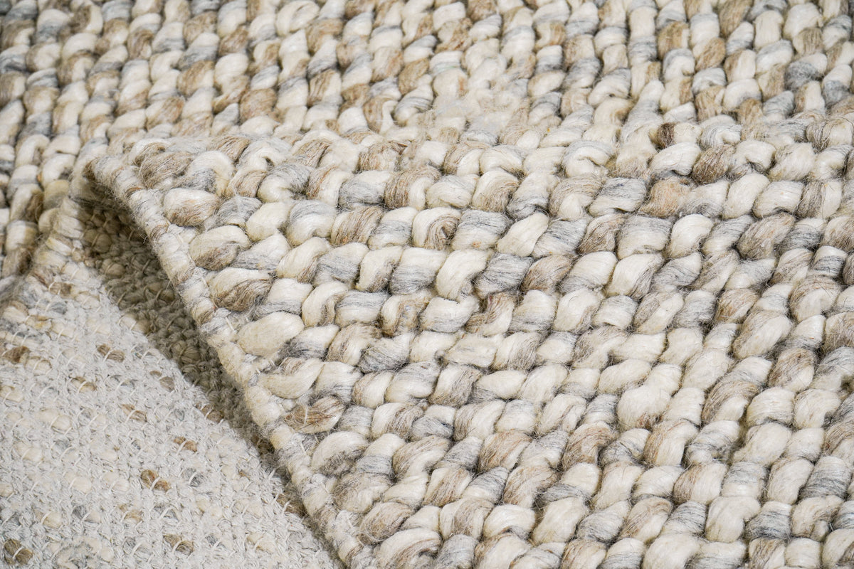 Gray Cashew Loops — wool rug with a folded corner revealing the underside and edge construction