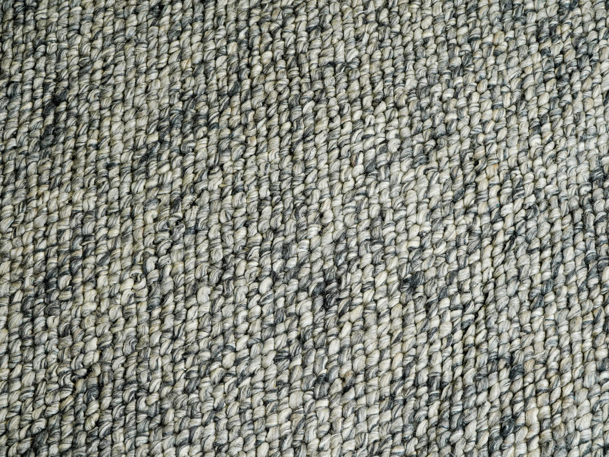 Cashew Loops — Wool rug with close diagonal rows and scattered darker gray accents