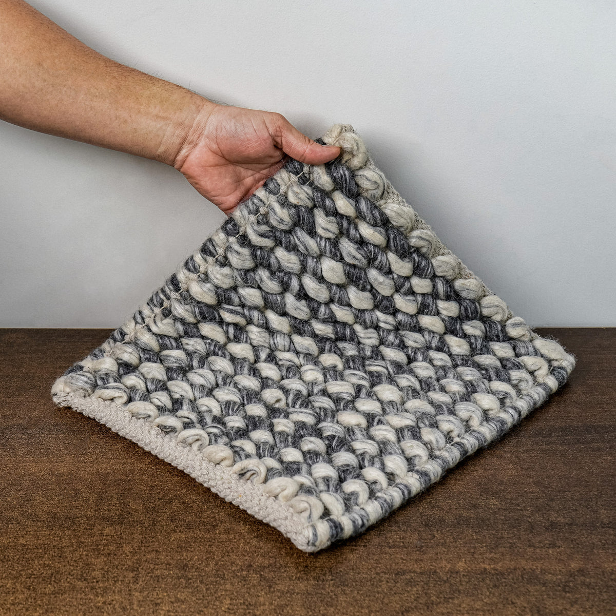 Gray Cashew Loops — Wool rug styled in a living room, highlighting the drape of its lifted corner