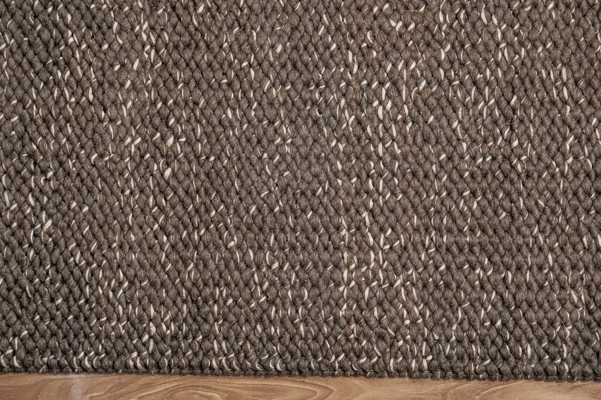 Cashew Loops — brown wool rug surface and straight lower edge viewed from above