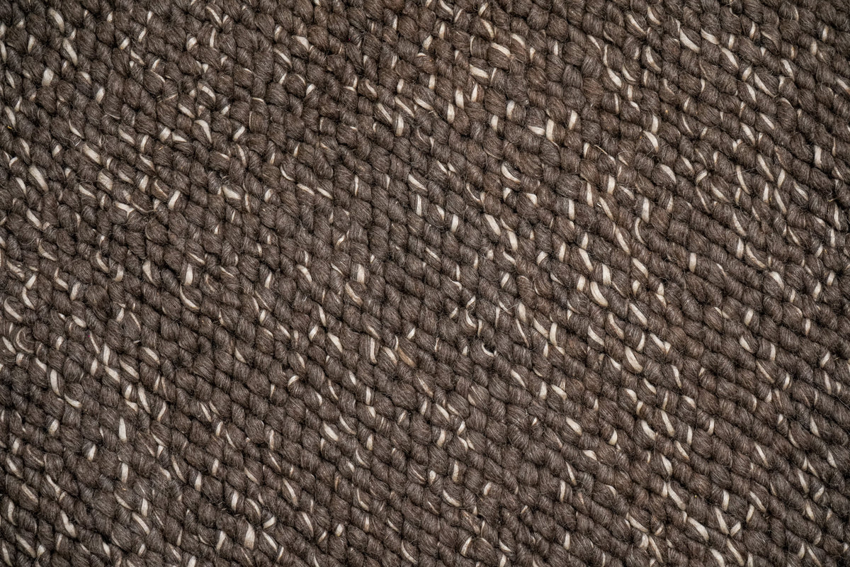 Cashew Loops — close overhead view of brown wool loops with scattered ivory strands