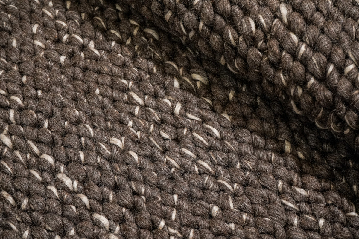 Cashew Loops — brown wool rug folded back over its textured loop surface