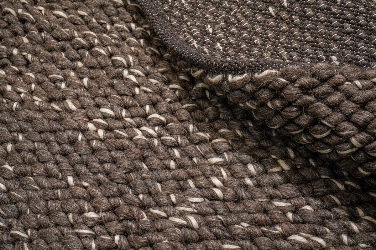 Cashew Loops — folded brown wool rug with the reverse above and chunky loop surface below
