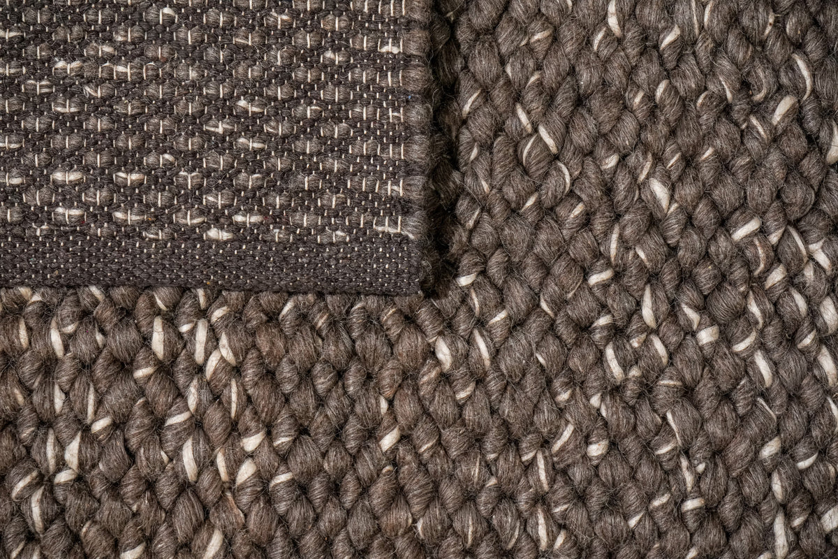 Cashew Loops — overhead view of the brown wool rug's reverse corner against its brown and ivory face