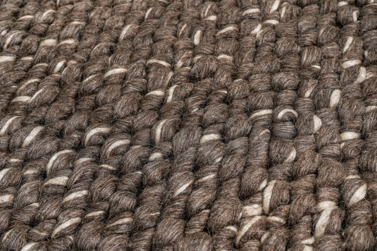 Cashew Loops — detailed angled view of the brown wool rug's loop rows and ivory highlights