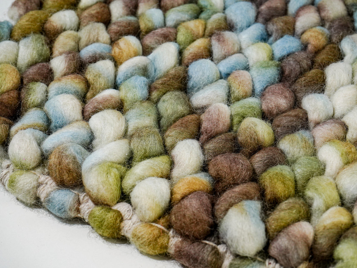 Multicolor Cashew Loop — Wool rug at a low angle showing raised loops and edge stitching