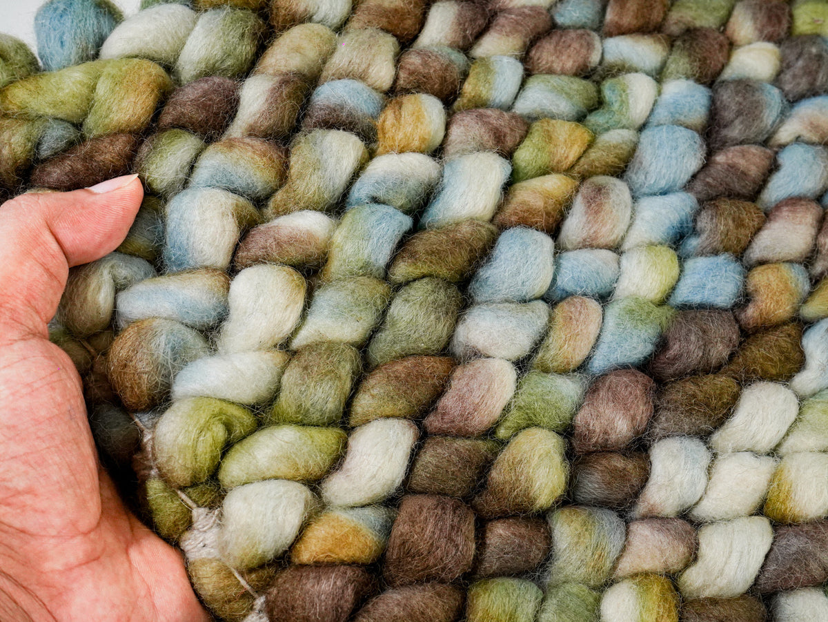 Multicolor Cashew Loop — Wool rug held in one hand to show the scale of the chunky loops