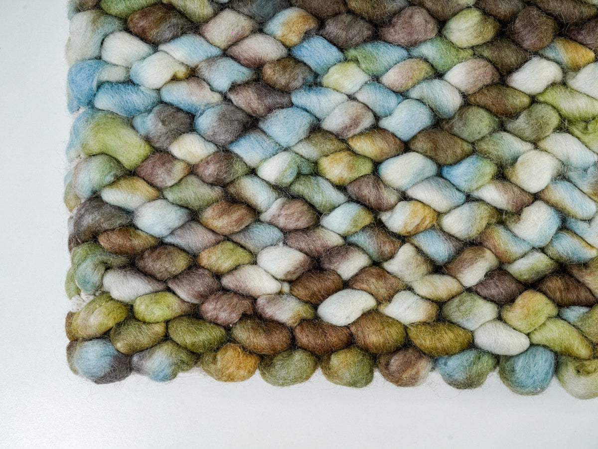 Multicolor Cashew Loop — Wool rug lower edge viewed from above, showing the rounded loop outline