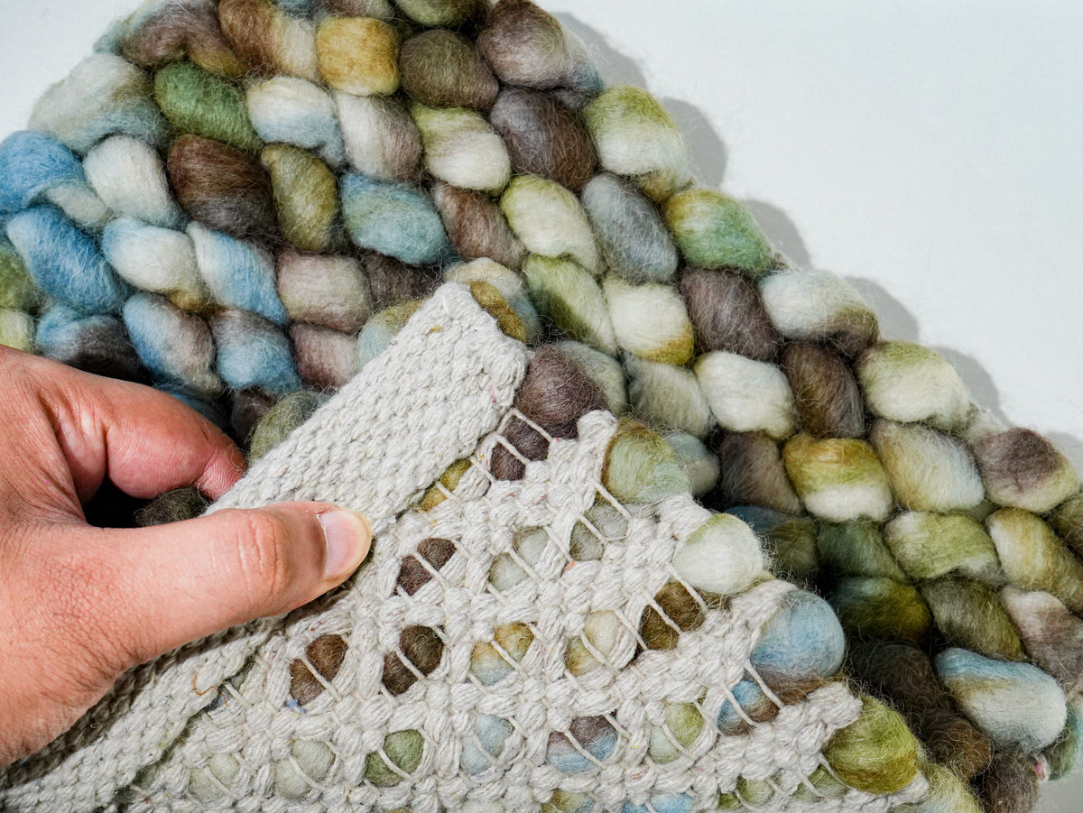 Multicolor Cashew Loop — Wool rug corner folded back by hand to reveal the underside construction