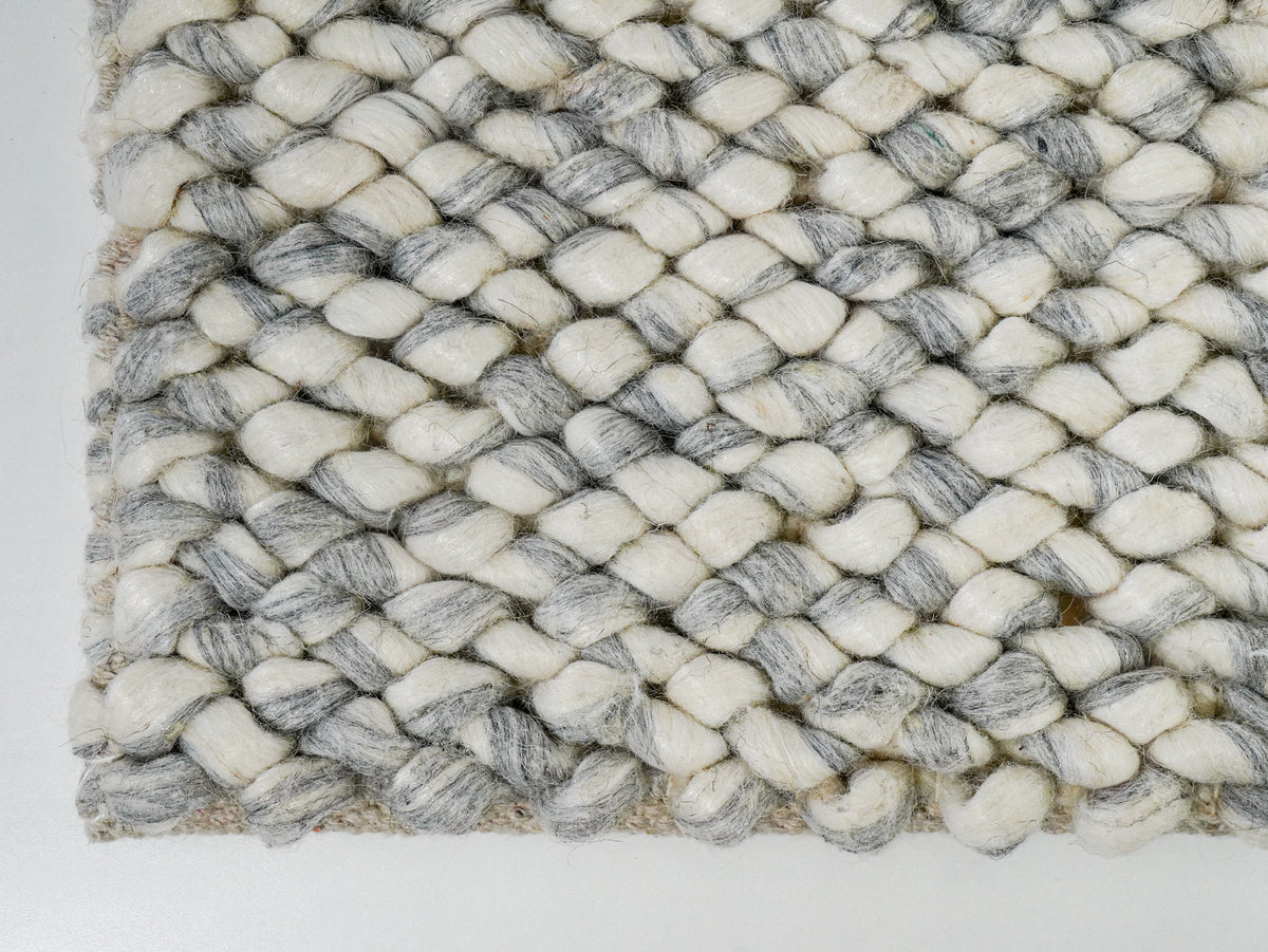 Gray Cashew Loop — Wool rug showing the lower-left corner and textured edge