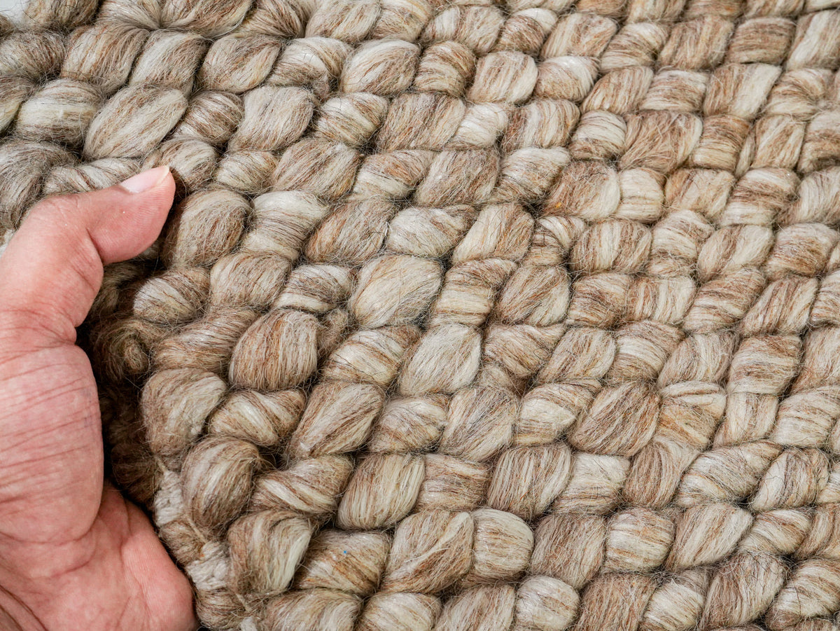 Beige Cashew Loop — Wool rug, hand holding the sample beside its chunky loop surface