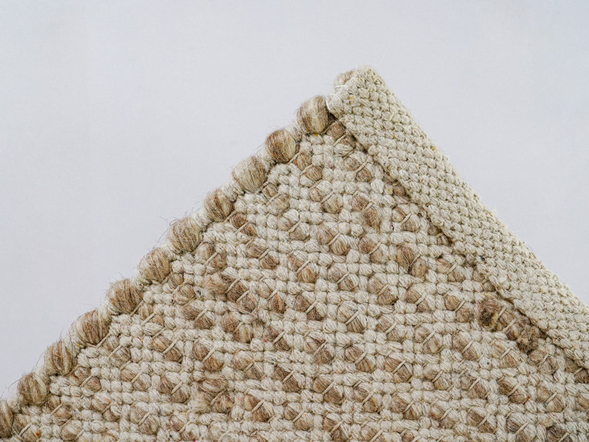 Beige Cashew Loop — Wool rug, reverse corner showing the folded edge finish