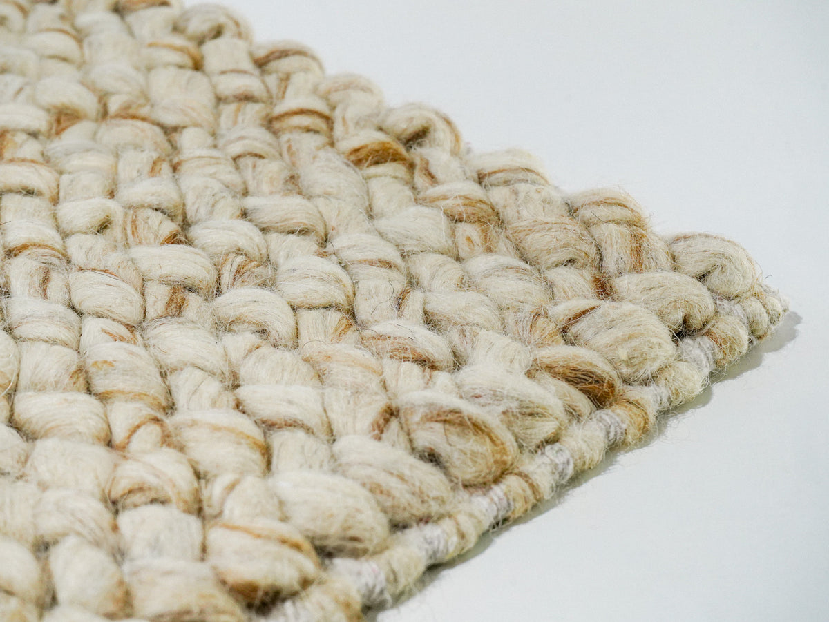 Beige Cashew Loop — Wool rug, oblique corner view showing loop texture above the edge finish