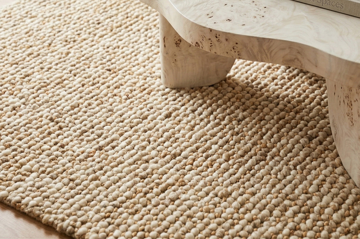 Loops With Jute — Beige Wool rug with rows of loops beneath the legs of a pale coffee table