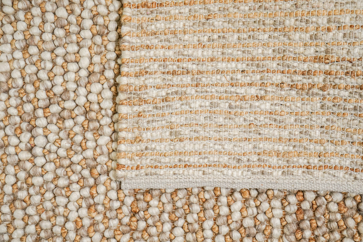 Loops With Jute — Beige Wool rug with a section folded back to show the underside weave and edge binding
