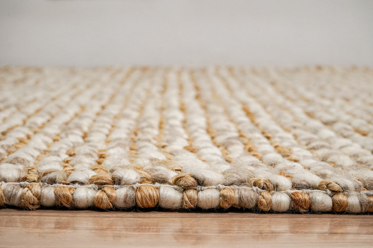 Loops With Jute — Beige Wool rug seen at floor level with the front edge in focus and loop rows receding behind it