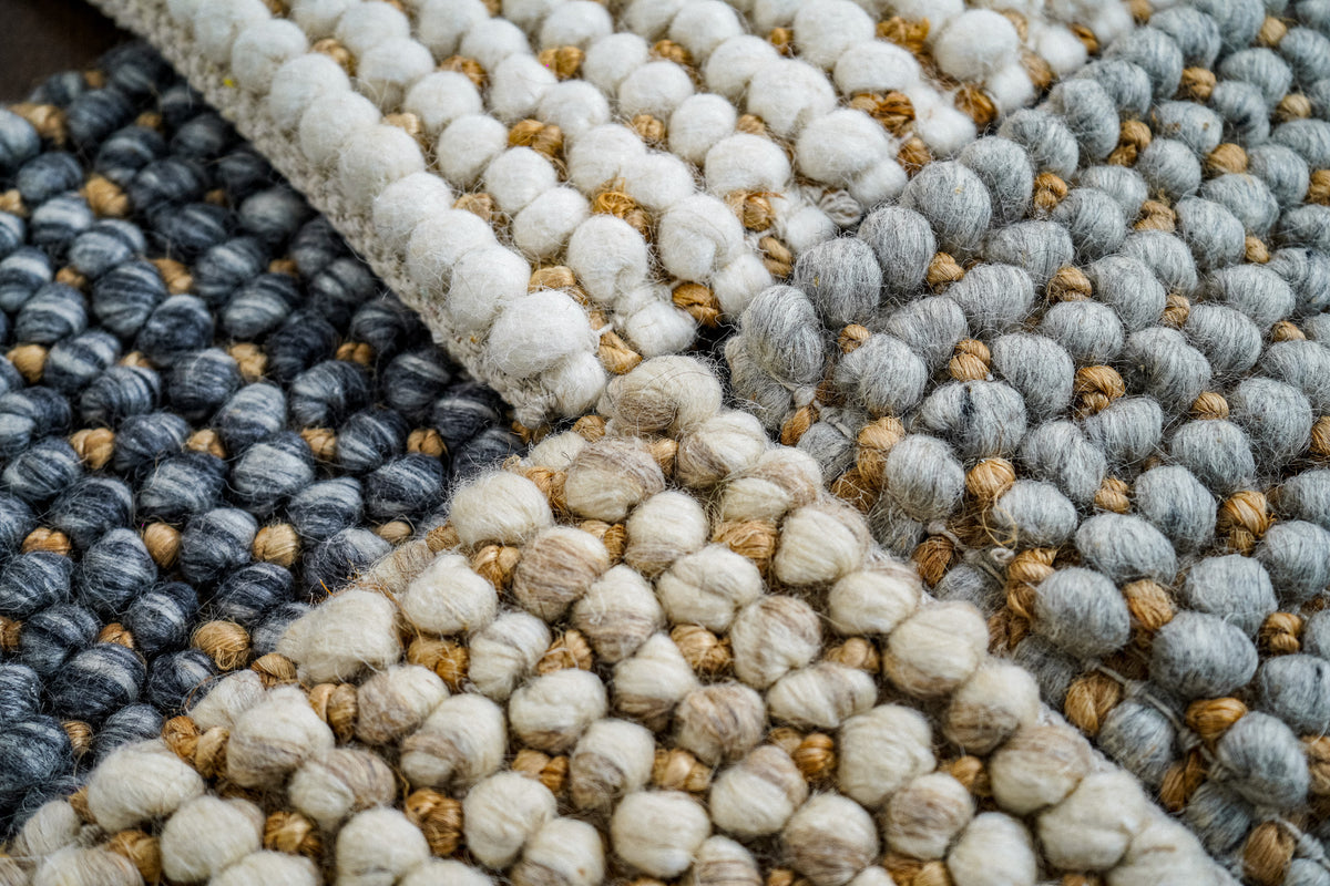 Loops With Jute — folded ivory wool rug sample at the upper right of an arrangement of textured samples