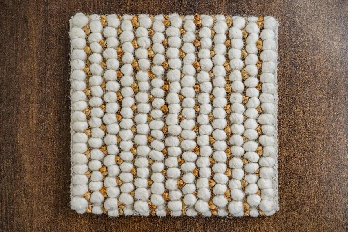 Loops With Jute — angled close-up of ivory wool loops, golden-brown jute and a finished corner