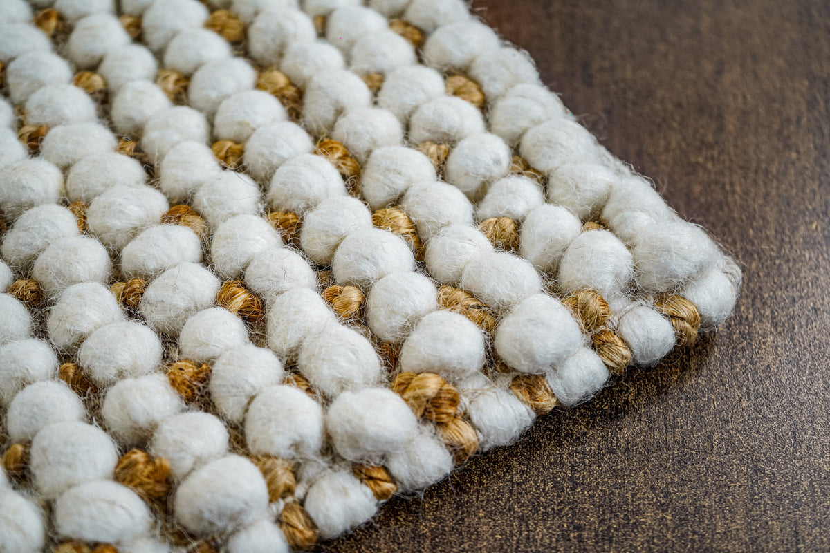 Loops With Jute — ivory wool rug sample overlapping other samples in a close-up texture arrangement