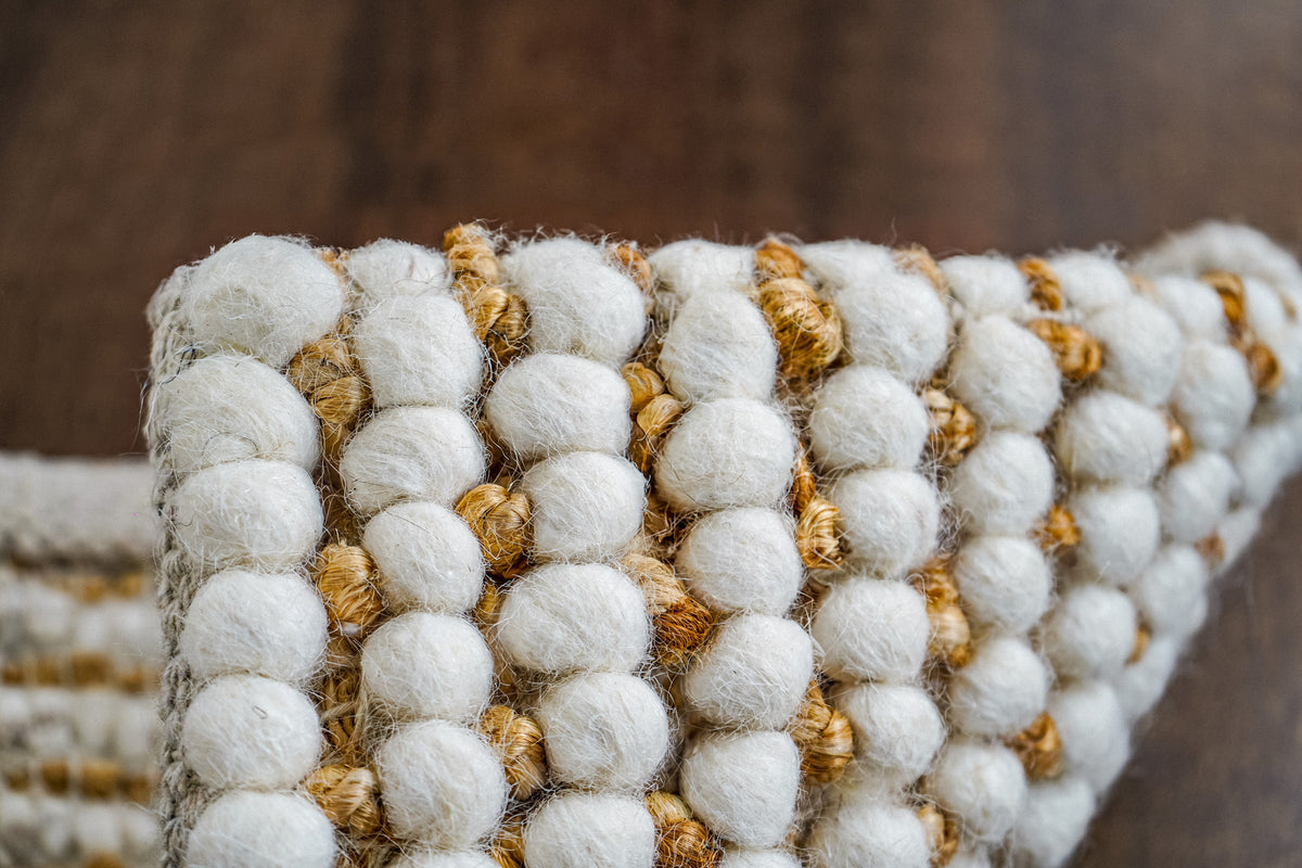 Loops With Jute — low side view of the ivory wool rug edge and repeating loop rows