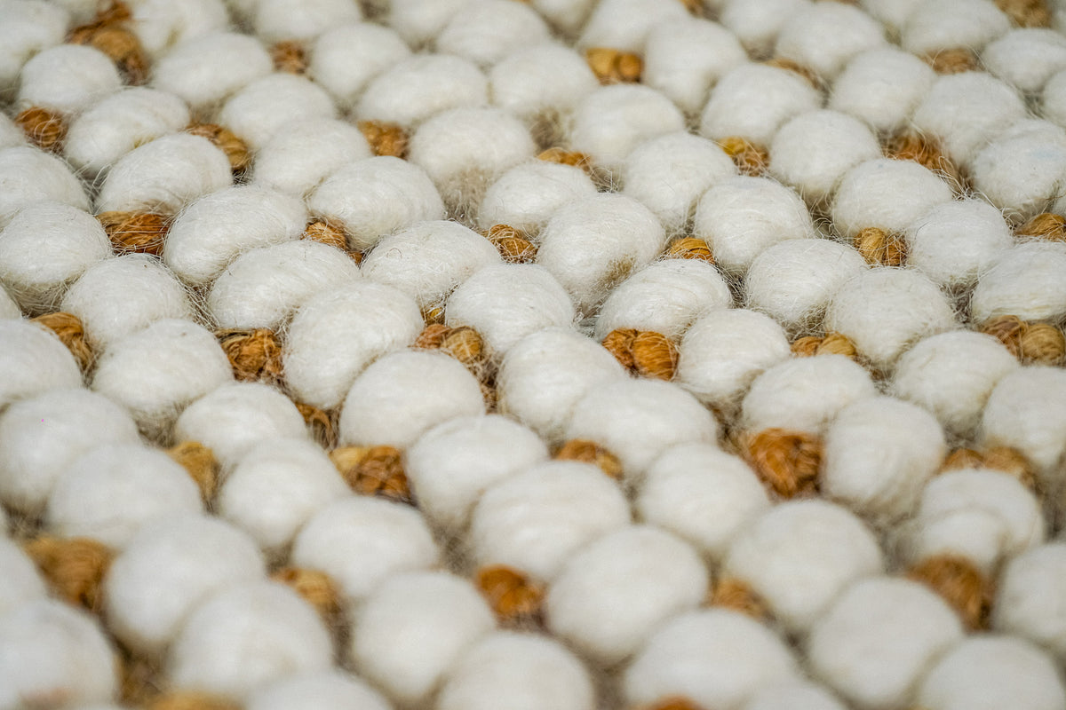 Loops With Jute — ivory wool rug sample lifted to reveal its underside and woven edge bands