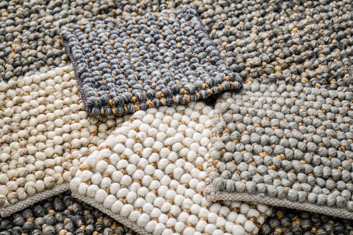 Loops With Jute — ivory wool rug sample in the lower left of a spread of textured rug samples