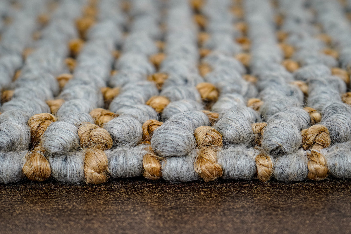 Loops With Jute — low side view of the gray wool rug's loop pile and finished edge