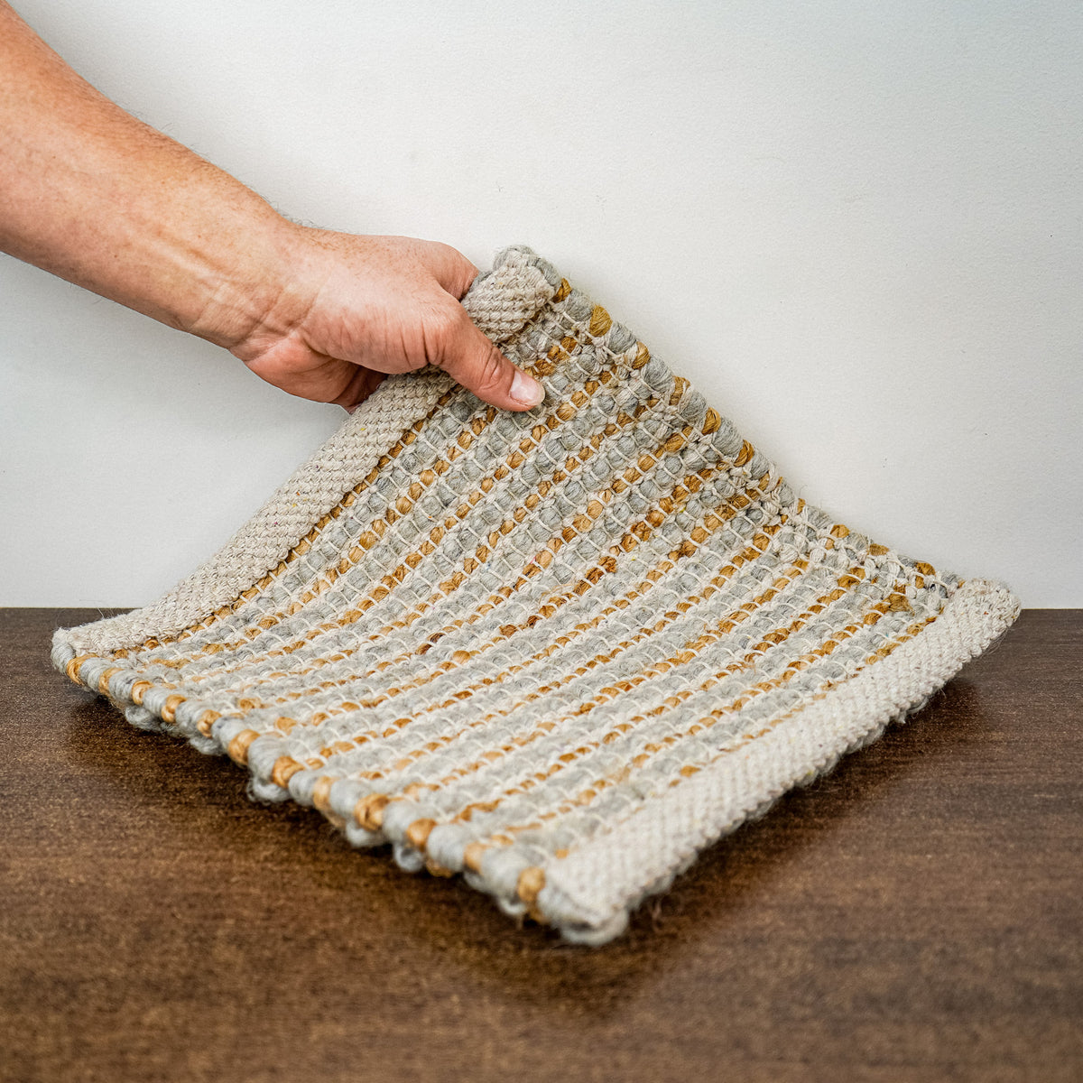 Loops With Jute — gray wool rug sample lifted to show its underside and bound edges