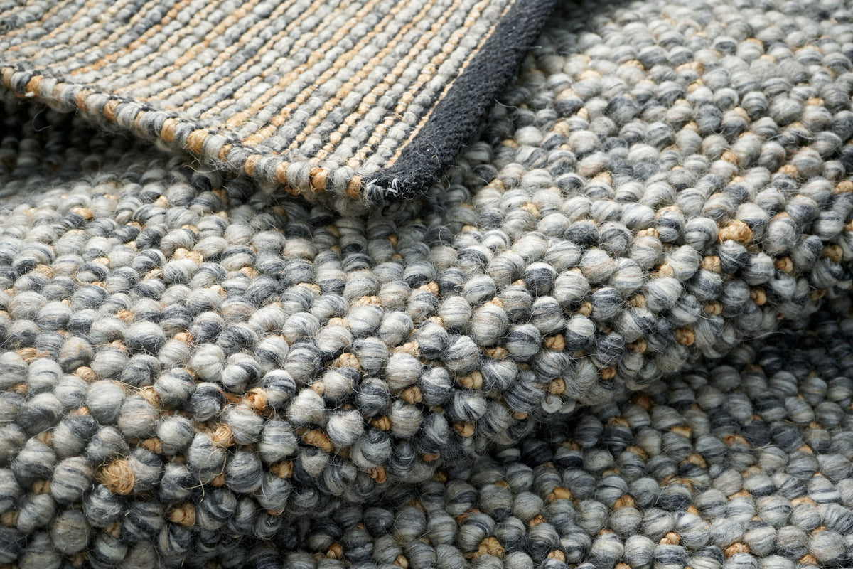 Loops With Jute — Gray Wool rug with a folded corner showing the underside above the looped surface