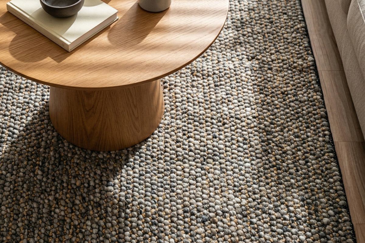Loops With Jute — Gray Wool rug styled in a living room beneath a round wood coffee table beside a sofa