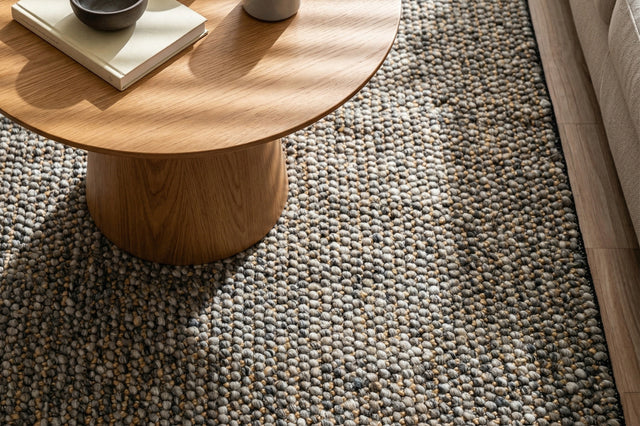 Loops With Jute — Gray Wool rug styled in a living room beneath a round wood coffee table beside a sofa
