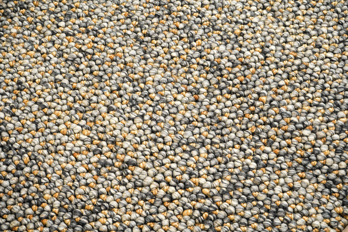 Loops With Jute — close-up of the weave, pile and edge finish, focused on the weave structure of the gray and golden-tan…