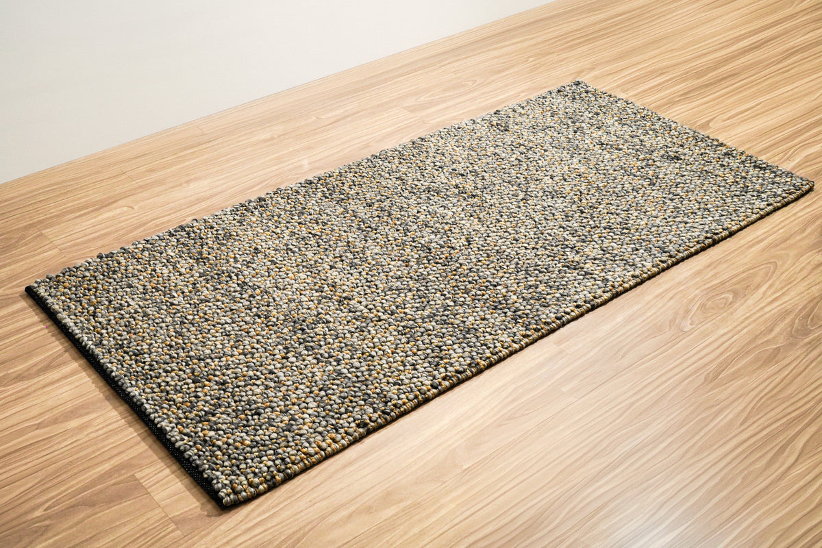 Loops With Jute — Gray Wool rug shown in full at an angle on a light wood floor
