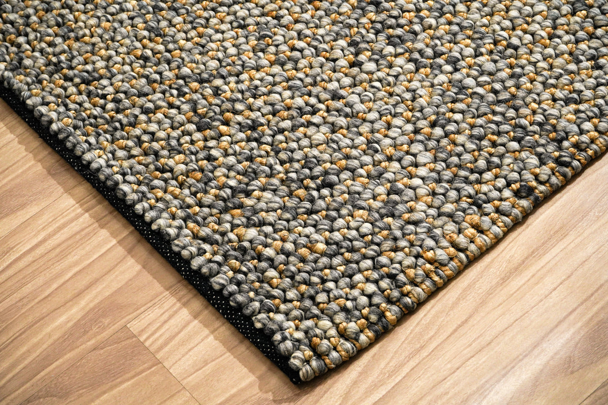 Loops With Jute — Gray Wool rug corner close-up showing the looped surface and dark edge binding