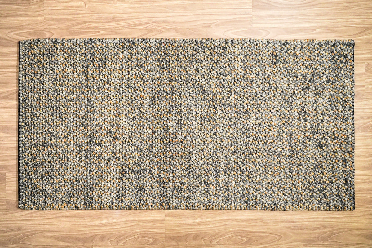 Loops With Jute — Gray Wool rug shown as a full rectangle from overhead with wood flooring around all sides
