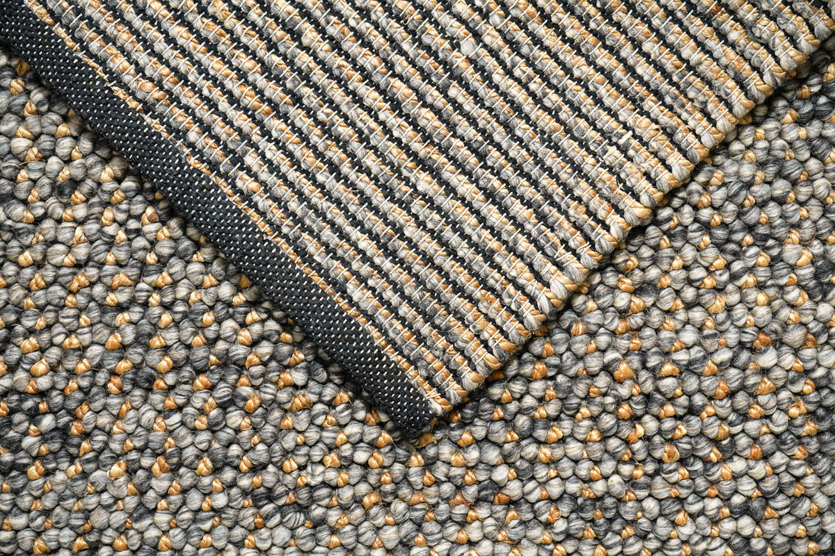 Loops With Jute — Gray Wool rug with its corner turned over diagonally to reveal underside rows and dark binding