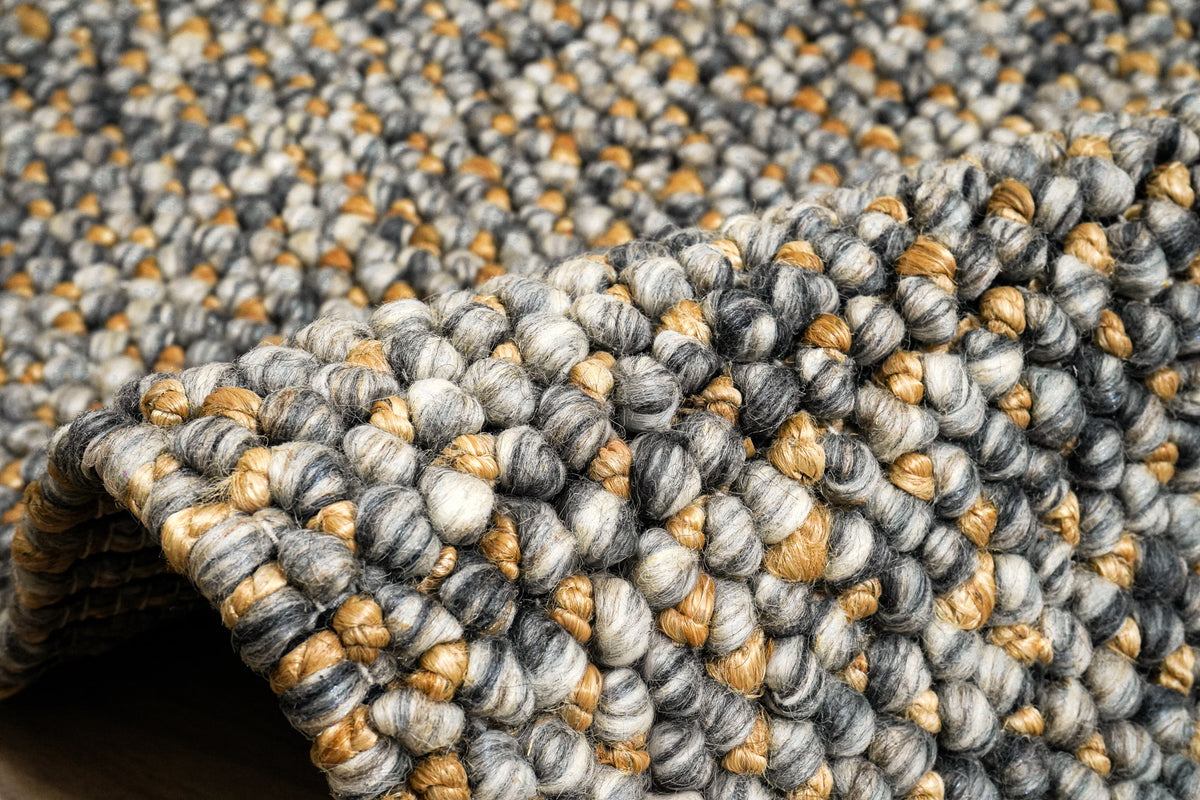 Loops With Jute — Gray Wool rug bent into a raised fold, showing the loop texture across the curve