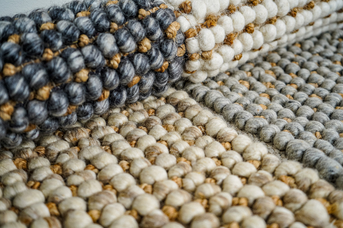 Loops With Jute — folded gray wool rug sample at upper left above overlapping samples