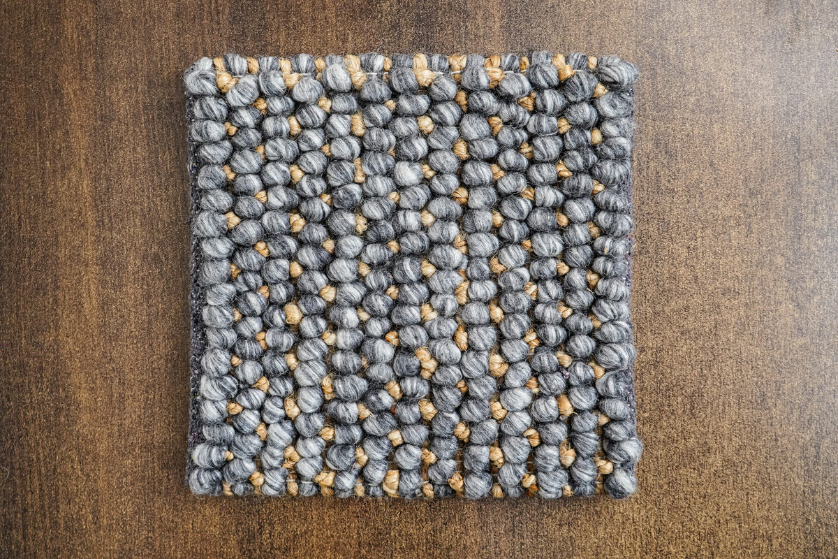 Loops With Jute — gray wool rug sample viewed from above, laid flat on a wood surface