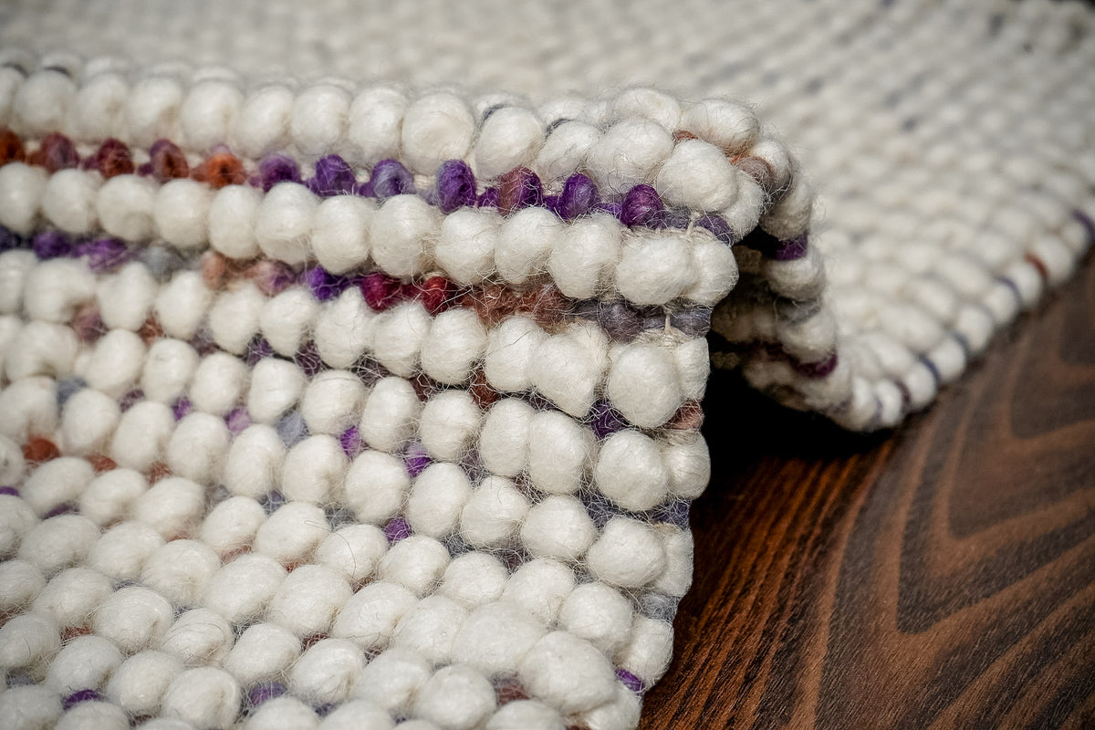 Alter Loops — Purple Wool rug bent into a fold, showing the loop surface along the curved edge