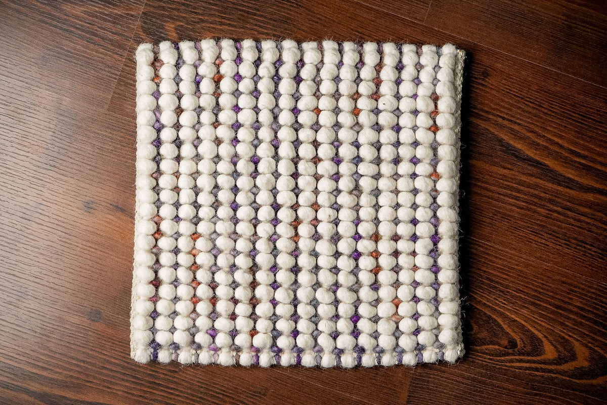 Alter Loops — Purple Wool rug square sample viewed from above on brown wood flooring