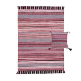 Pink striped dhurrie rug in a bedroom setting