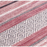 Pink striped dhurrie rug corner detail with braided edge