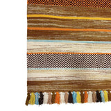 Full view of beige striped kilim rug on wood floor