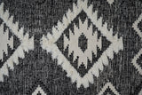 Black wool rug under a bed in a bedroom