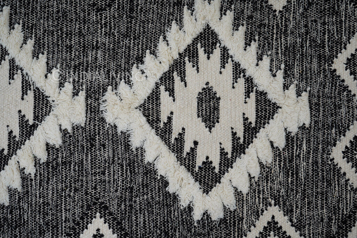 Black wool rug under a bed in a bedroom